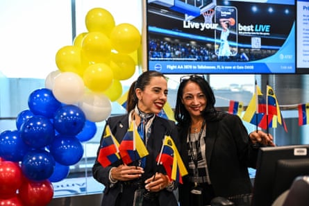 American Airlines staff holding Venezuelan flags in front of a balloon arch