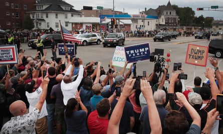 Trump supporters and protesters watch as the motorcade carrying Donald Trump passes by in Kenosha, Wisconsin.