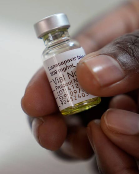 A hand holds a vial of lenacapavir