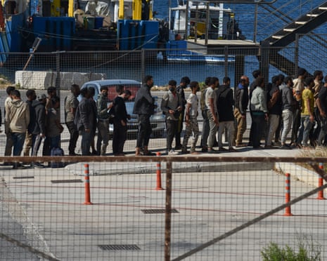 Migrants who arrived from Libya on the ship Messinian Spire queue for processing at Lavrio, Greece, on 10 July 2025.