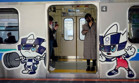 Commuters wearing face masks stand in a train decorated with Tokyo Olympic and Paralympic Games mascots in Tokyo, Japan. Japan is considering vaccinating Olympic athletes ahead of the rest of the population. 
