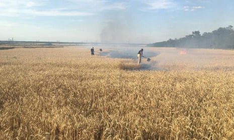 Rescuers extinguish a fire in a wheat field in the Donetsk region after Russian shelling
