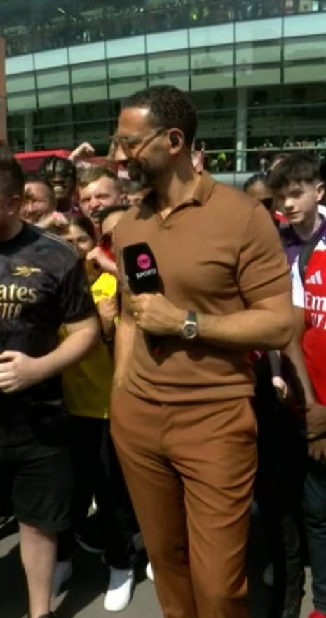 Rio Ferdinand in brown polo shirt and trousers