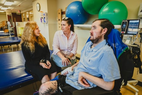 A doctor speaks with a woman next to her patient