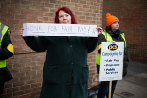 York, UK. A civil servant holds a ‘Honk for Fair Pay’ banner’ at an official picket line outside York job centre, as workers go on strike on the largest scale strike day in over a decade