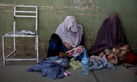 Two women wait outside a ward with their young babies at Kandahar’s Mirwais hospital