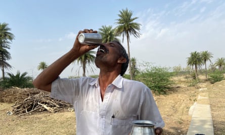 Farmer Hemraj Sharma drinks water from a recharged well