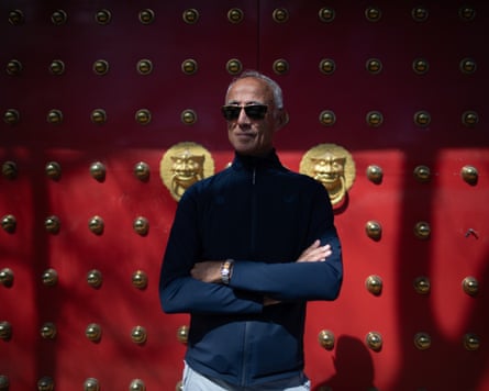 Andrew Ridgeley standing in front of a large red door with ornate gold fixings