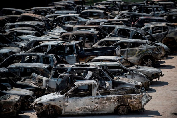 Burnt cars parked outside a football stadium following a wildfire at the village of Rafina, near Athens