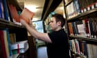 A mature student at Aberystwyth University taking a textbook from the shelf of the Law library, UK
