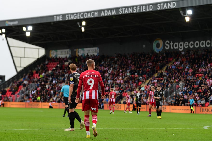 Jay Stansfield in front of the Adam Stansfield Stand at Exeter City.