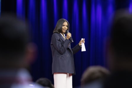 A woman speaks into a microphone onstage