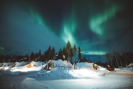 Snow, cabins, forest and the northern lights