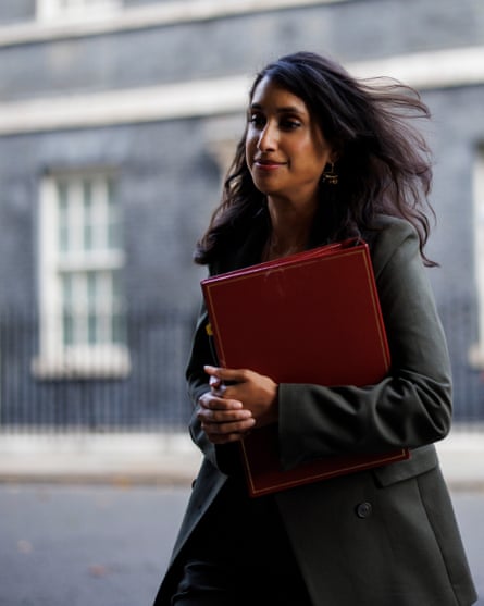 British secretary of state for energy security and net zero Claire Coutinho walking with a red folder under her arm.