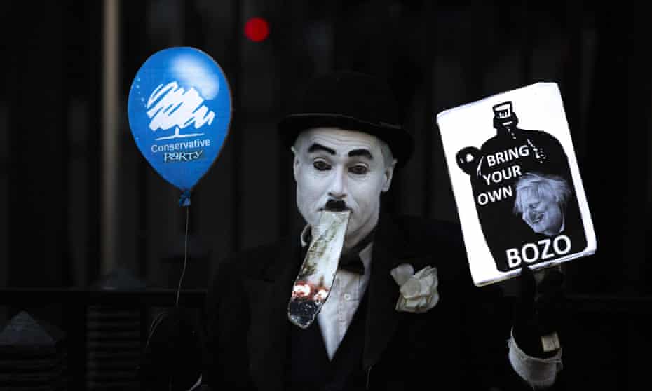 A man dressed as Charlie Chaplin protests against the prime minister’s flouting of coronavirus lockdown rules.