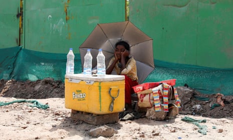 A girl sells water on a hot summer day in New Delhi, India.