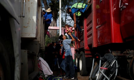 A migrant helps a girl get off a truck as they hitch a ride from Santo Domingo Ingenio to Matías Romero Avendano on 8 November.