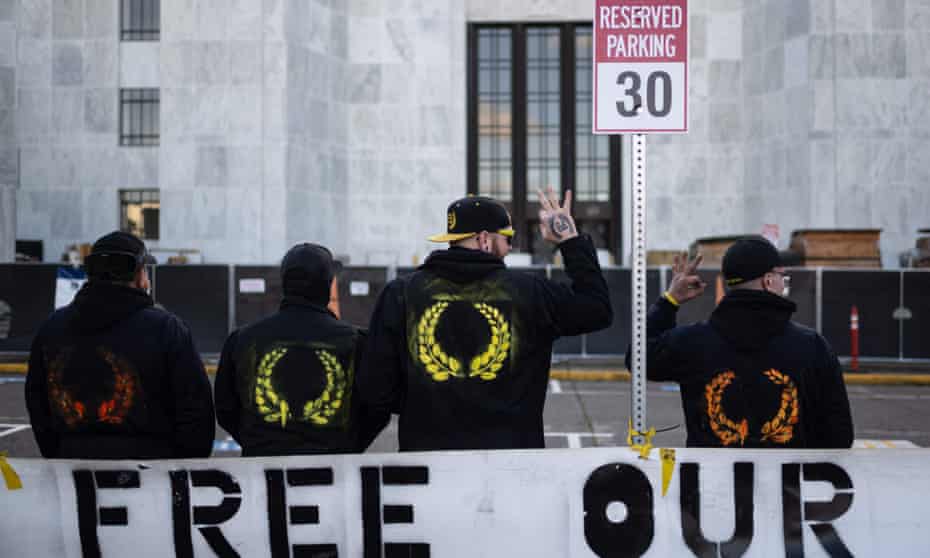 Members of the Proud Boys make the ‘OK’ sign as they pose in front of the Oregon state capitol building during a far-right rally on 8 January in Salem.