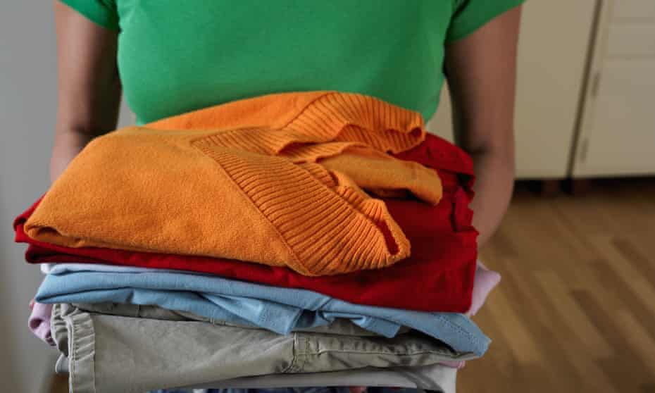 Woman holding pile of clothes