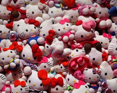 A large pile of plush Hello Kitty toys with colourful bows and outfits, at a London exhibition