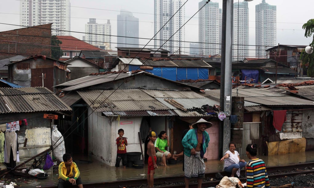 People rest around the railway track near their flood-affected houses in the Tanah Abang slum area in Jakarta, Indonesia.