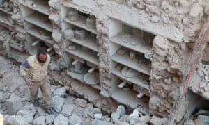 A civil defence member looks for survivors amid rubble of damaged houses after an airstrike on rebel-held Old Aleppo.