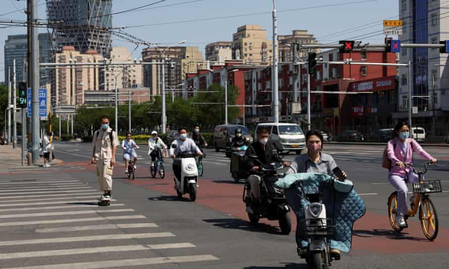 People riding vehicles in Beijing, China, today