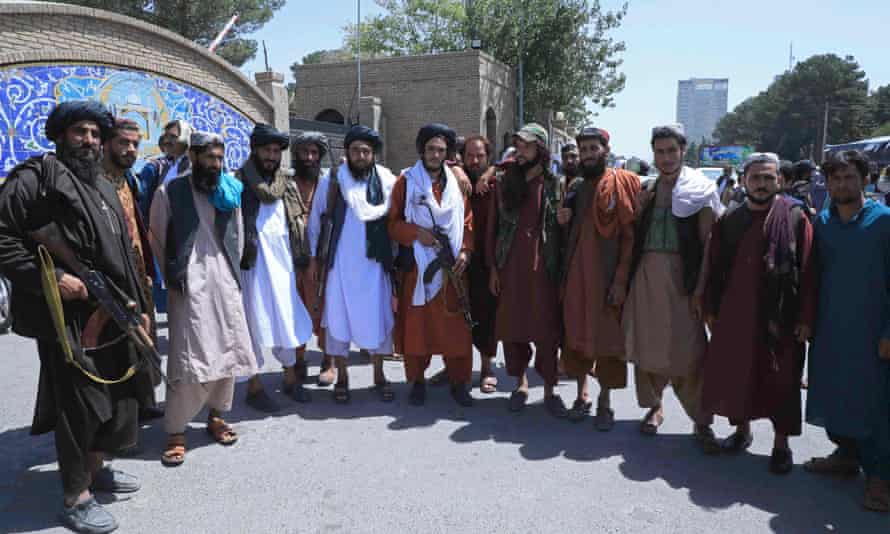 Taliban fighters pose as they stand guard in front of the provincial governorâs office in Herat on 14 August.