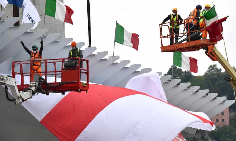 Construction workers install the final span of the new motorway bridge in Genoa