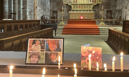 Lit candles sit around a framed picture of the boys in Shrewsbury Abbey