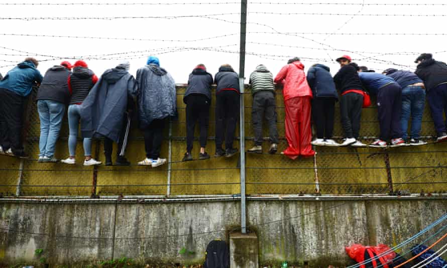 Fans watch the action over a wall .