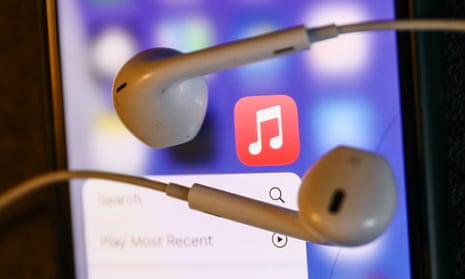 Headphones on a phone showing an Apple Music icon