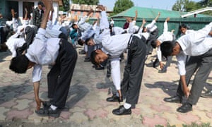 Children in school uniform touch their toes