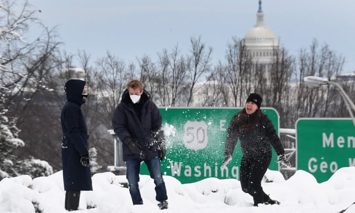 People throw snowballs in Arlington, Virginia as the US set a new global record of 1m daily Covid cases on Monday.
