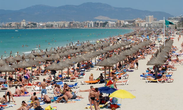 Sunbathers crowd a beach in Mallorca.