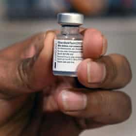 Hand holds a dose of the Pfizer-BioNTech Covid vaccine.