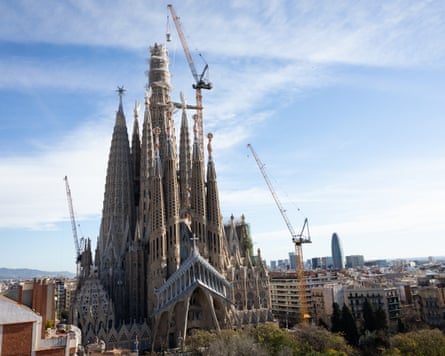 Cranes working on the construction of the Sagrada Familia against the backdrop of the Barcelona skyline