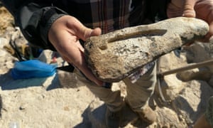 A researcher holds a mould for making a spearhead from molten copper.