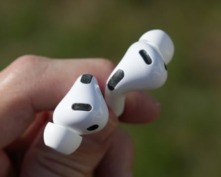 The AirPods Pro 3 earbuds held between fingers showing the air vents on the top.