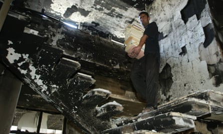 An Iraqi man collects books from destroyed Iraqi National Library in Baghdad, April 17, 2003.
