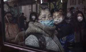 People wear pollution masks on a bus in China