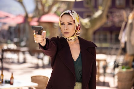 A woman in a black jacket and headscarf pointing a pistol