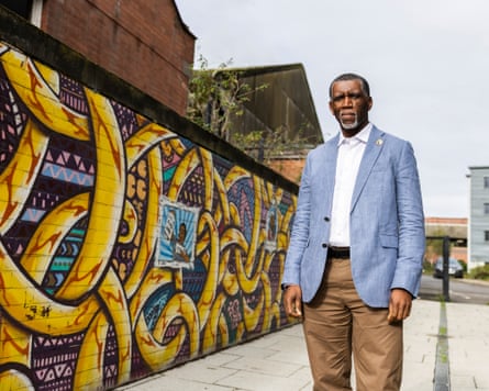 Clive Foster stands in front of a wall covered in graffiti art in Nottingham.