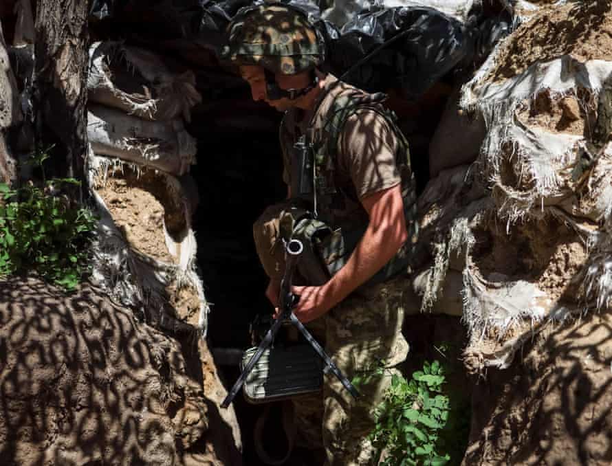 A Ukrainian service member holds a machine gun at a position on the front line in the eastern Donetsk region, Ukraine.
