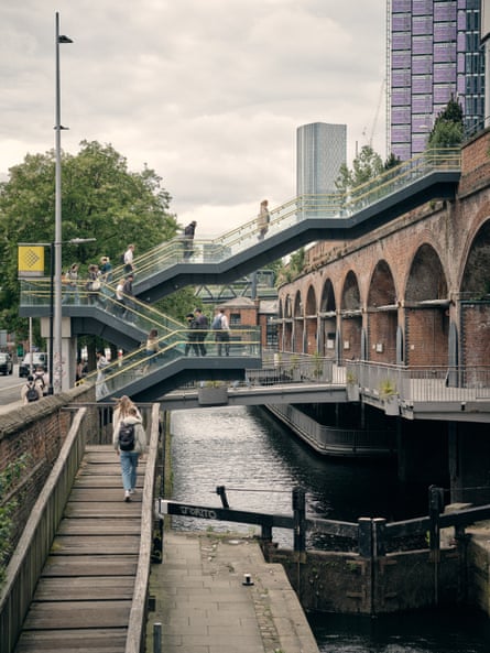 Commuters make their way to the Deansgate-Castlefield Metrolink stop in Manchester