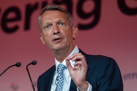 Andy Haldane gestures with his hand while speaking at microphones