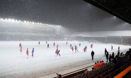 A view of play as snow covers the pitch.