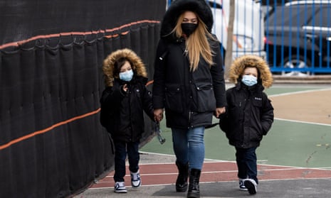 Two children wear face masks as they are walked into a school in New York City on 3 January. 