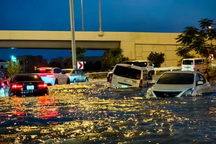 Cars sit abandoned in a flooded street 