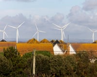 Turbines of Little Cheyne Court Wind Farm over the rooftops of Camber, seen from Camber Sands beach near Rye, East Sussex